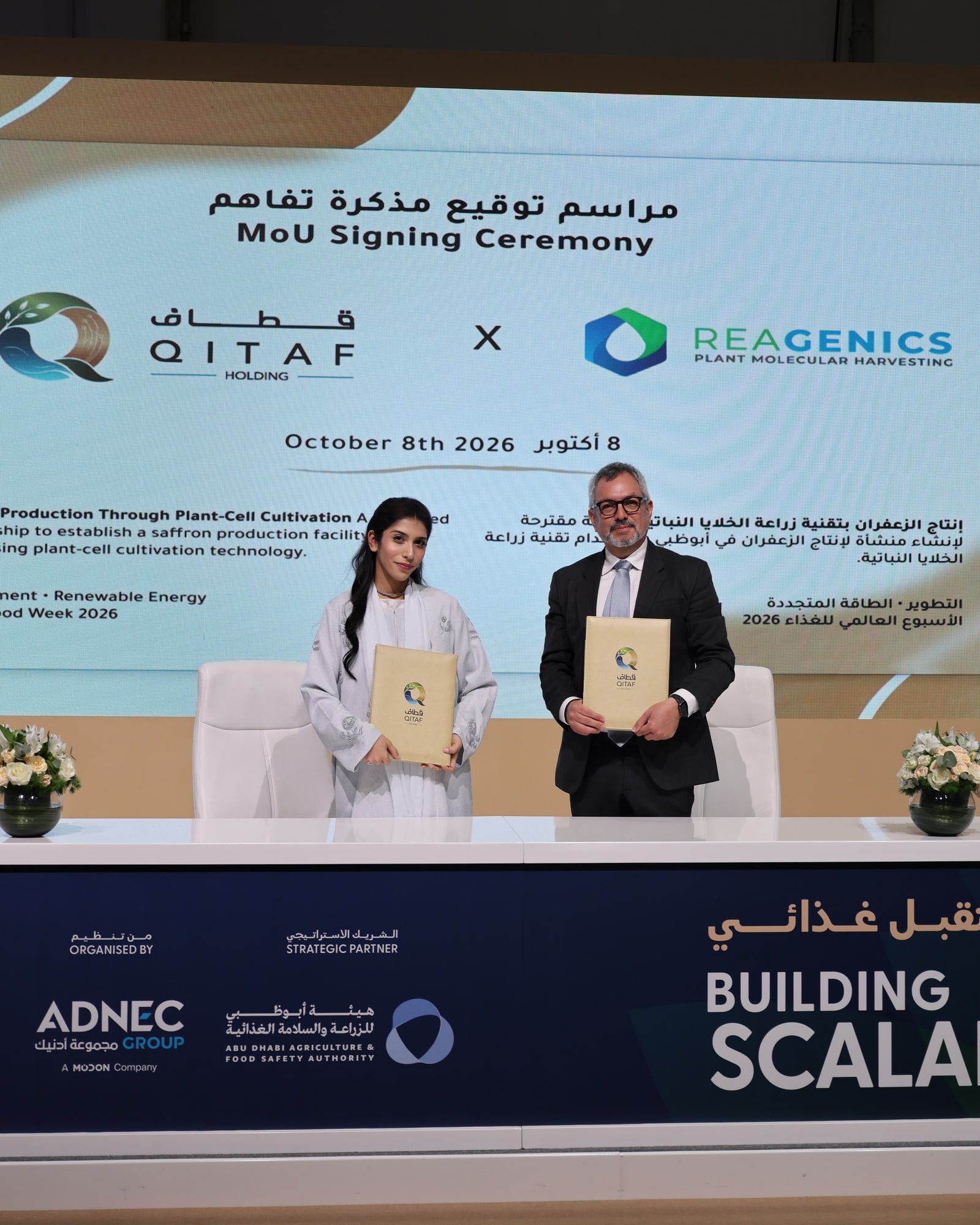 Eran Lagon and a QITAF representative holding signed agreement folders at the MoU ceremony in Abu Dhabi on 8 October 2026